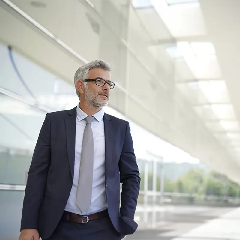 A gray haired man wearing a suit and tie