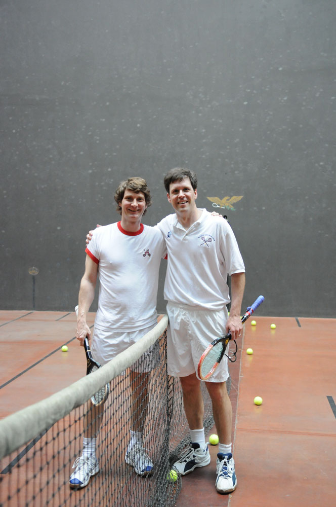 Two men smiling while playing tennis at GCU.