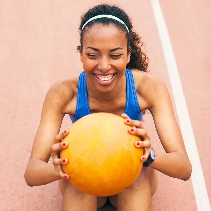 A young female athlete is holding a ball