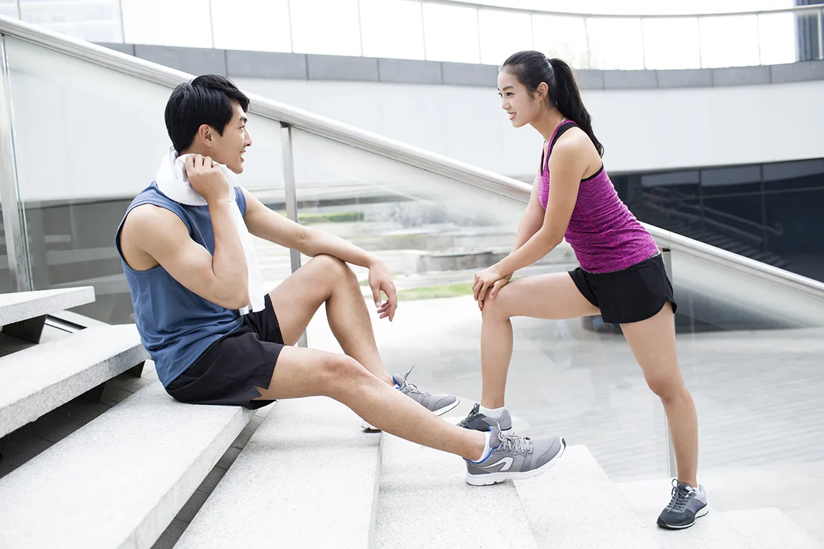 Young couple resting on the stairs after exercise