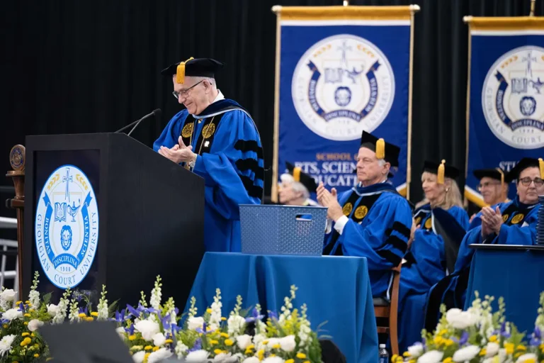 A man speaking at a podium during commencement