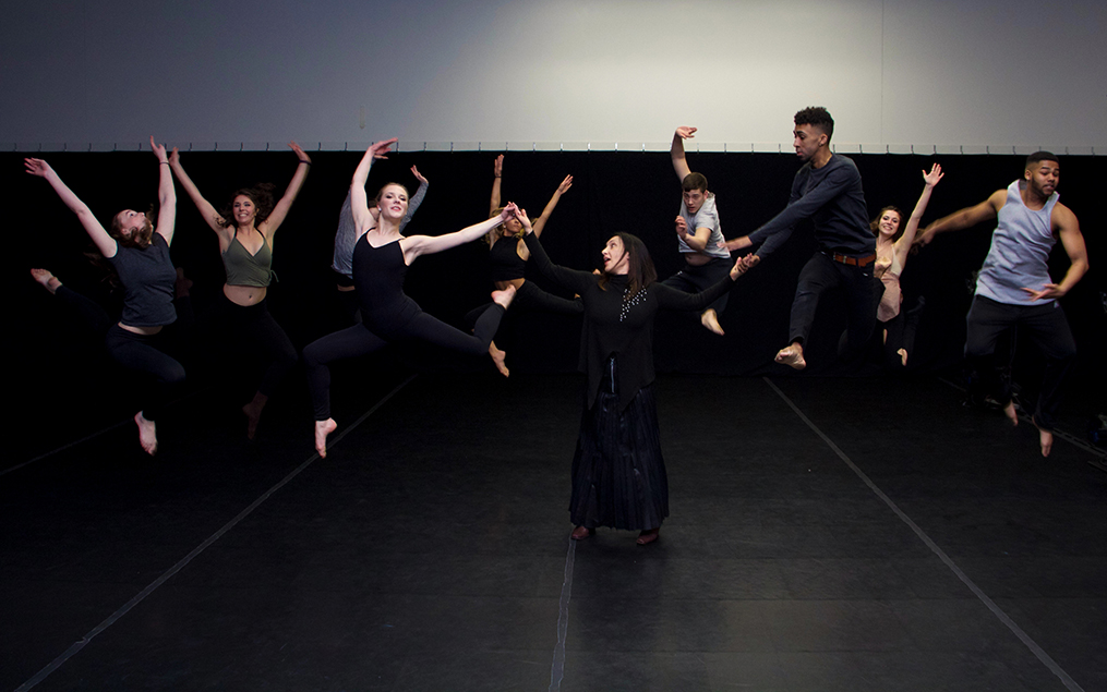 Dance students wearing black jumping