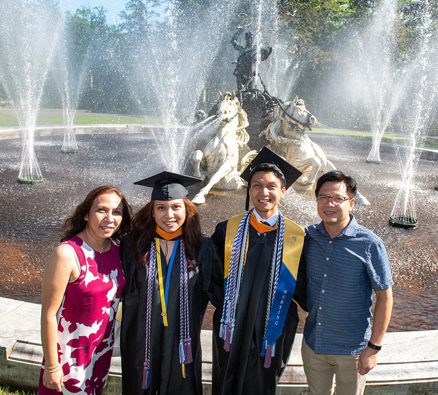 GCU graduation with graduates smiling in front of Apollo fountain.