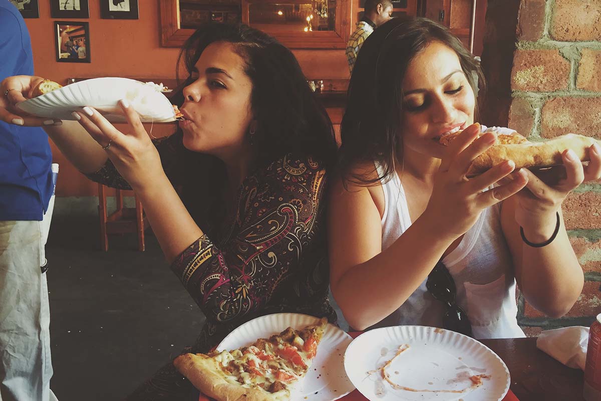 Two girls eating pizza
