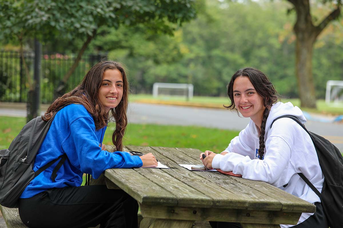 Two students sitting at a bench