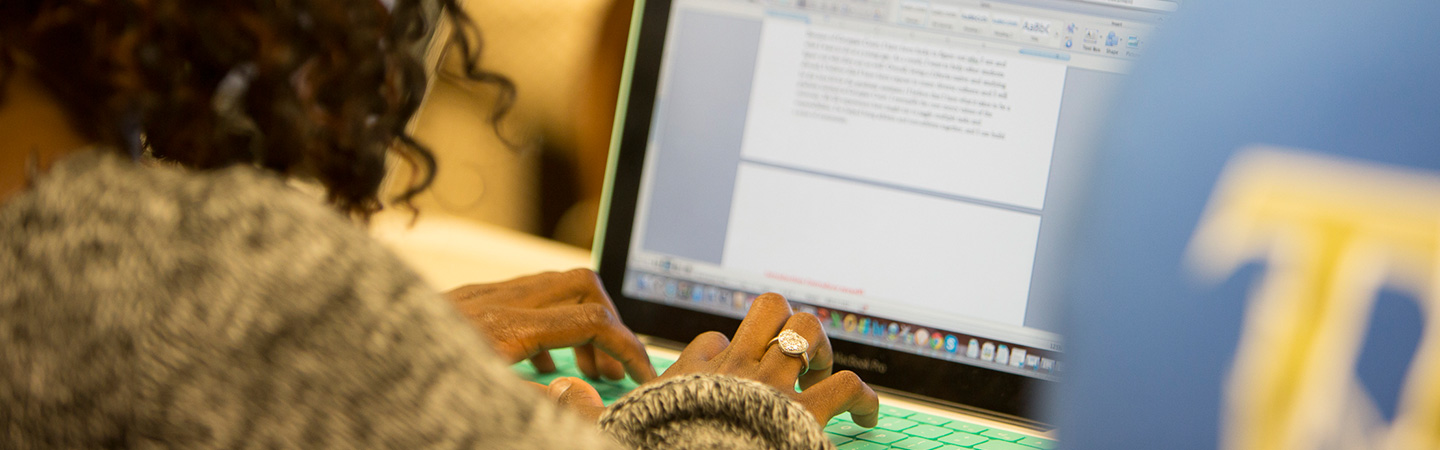 student typing on computer