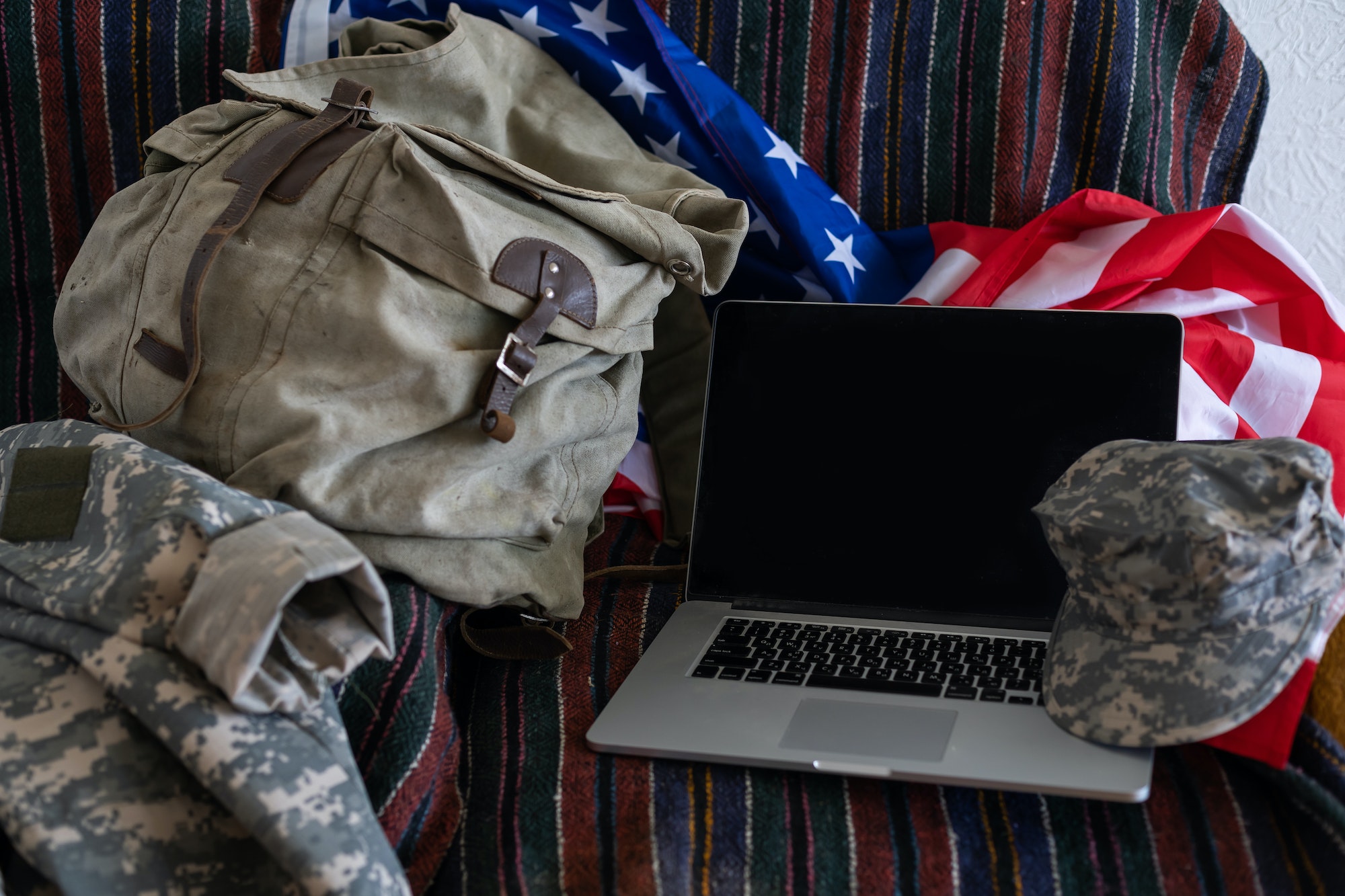 backpack and laptop against American flag. Military education