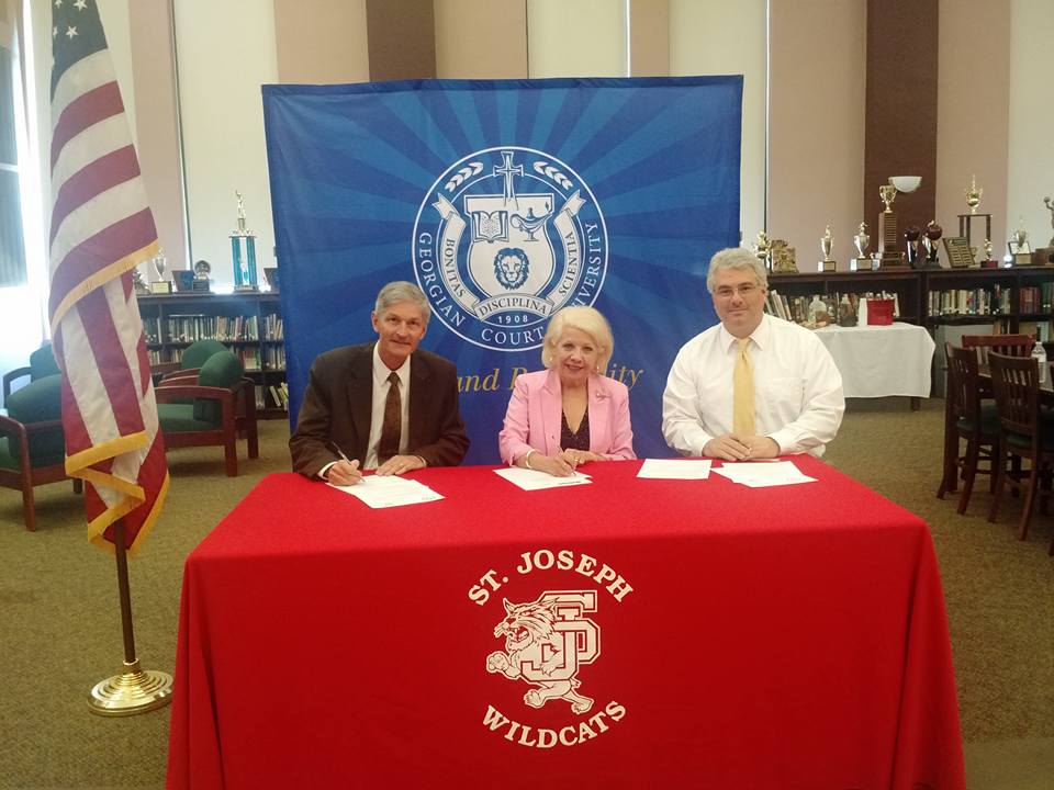 GCU president signing documents a ST. Joseph