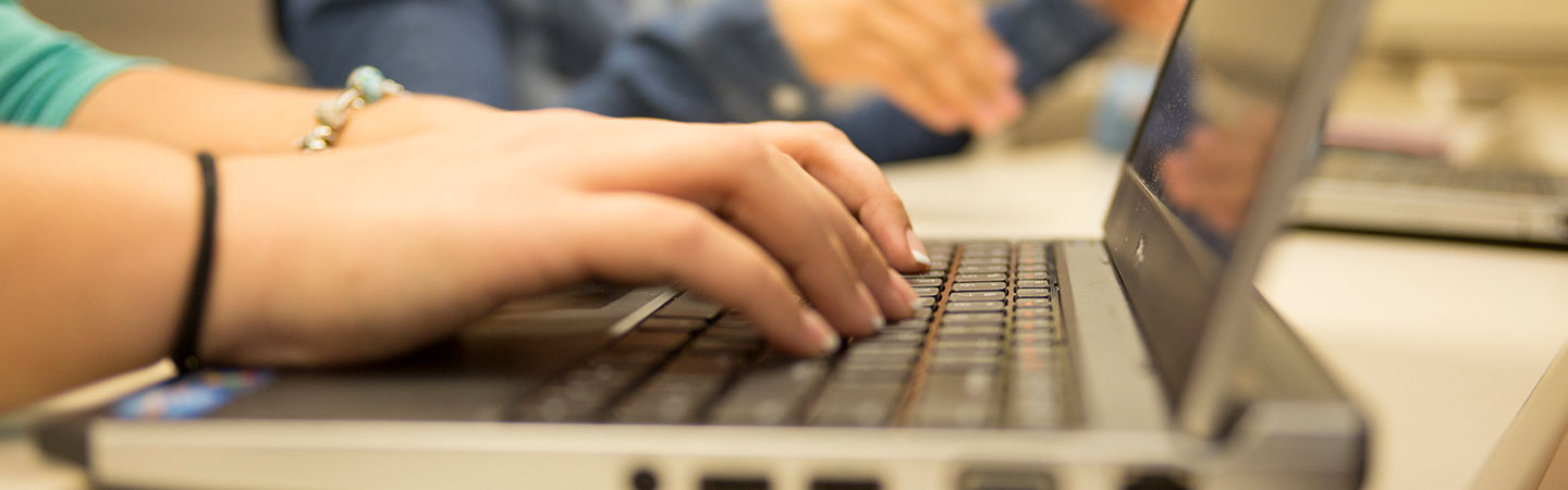 hands typing on a laptop's keyboard