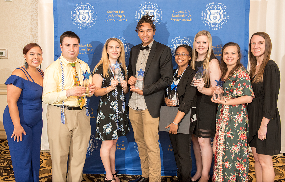 Group of students smiling with awards.