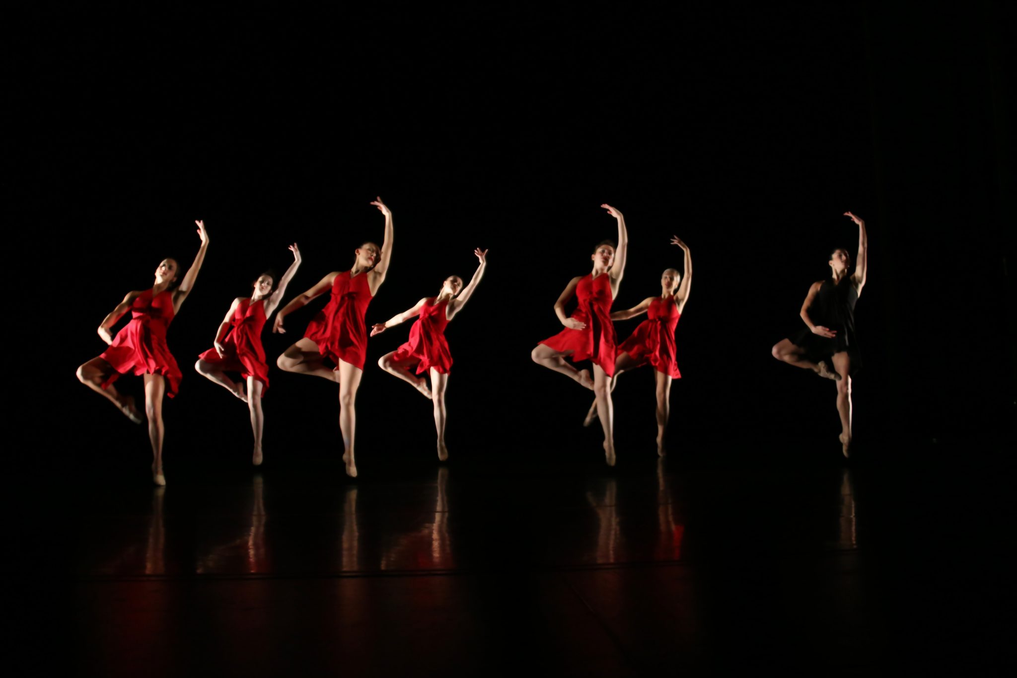 Dancers wearing red dresses, dancing on stage