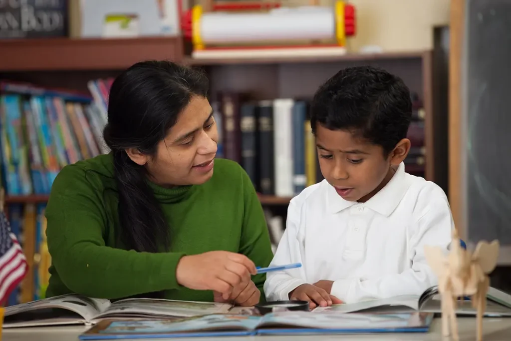 A female multisensory literacy teacher reading to a young boy