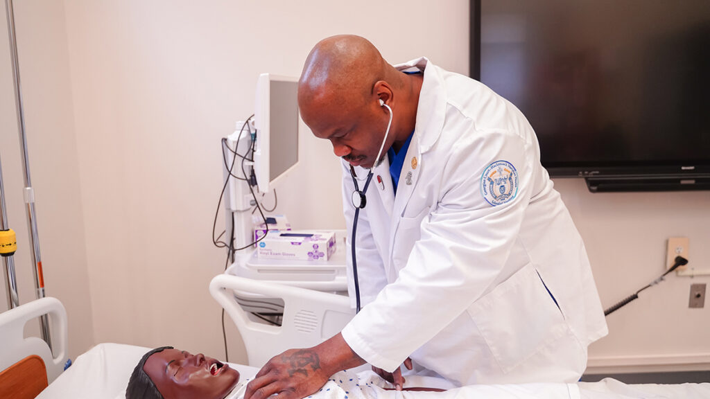nursing student examines manikin