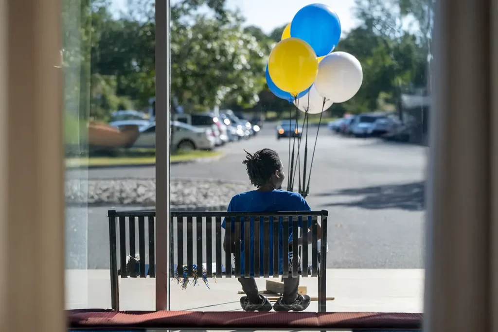 A Student. holding balloons