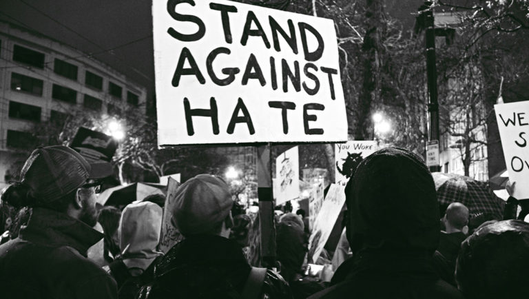 Protest with sign that says Stand Against Hate